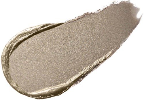 Ein beiges Make-up-Produkt, wahrscheinlich Lidschatten oder Gesichtspuder, auf einer Oberfläche mit strukturierter Kante verteilt.