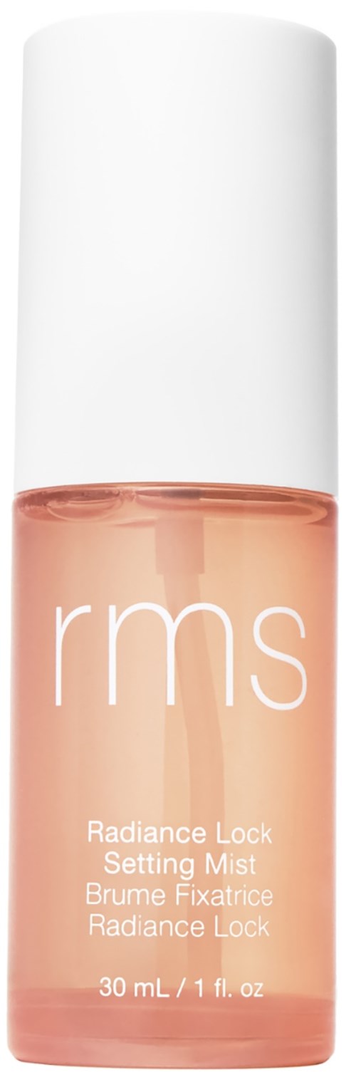 A small, transparent bottle with a white cap, containing light pink liquid, labeled 'rms Radiance Lock Setting Mist.'