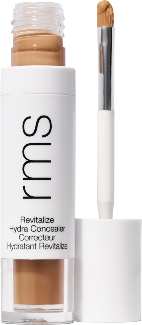 Eine weiße Flasche mit RMS hydrating concealer, mit einem cremefarbenen Stück und einem Pinselapplikator.