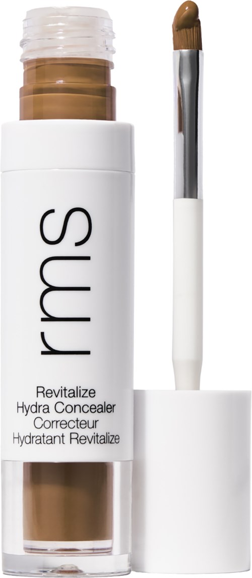 Eine weiße Tube mit durchsichtigem Deckel, gekennzeichnet mit 'rms' und 'Revitalize Hydra Concealer', enthält braunen Concealer.