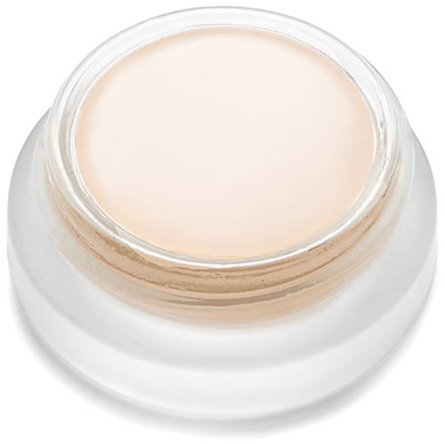Kleiner Behälter mit heller Creme oder Salbe und klarem Deckel, fast voll, auf einer weißen Oberfläche.
