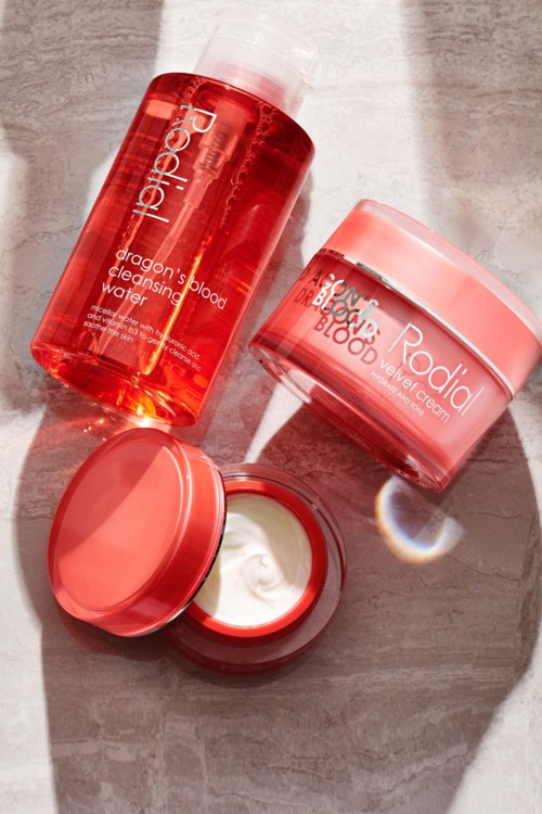 Two skincare products: a tall red bottle and a pink jar, both labeled 'Radiance' and placed on a light surface.