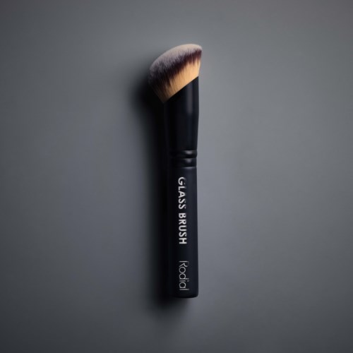 A black makeup brush with soft, angled bristles on a gray background.