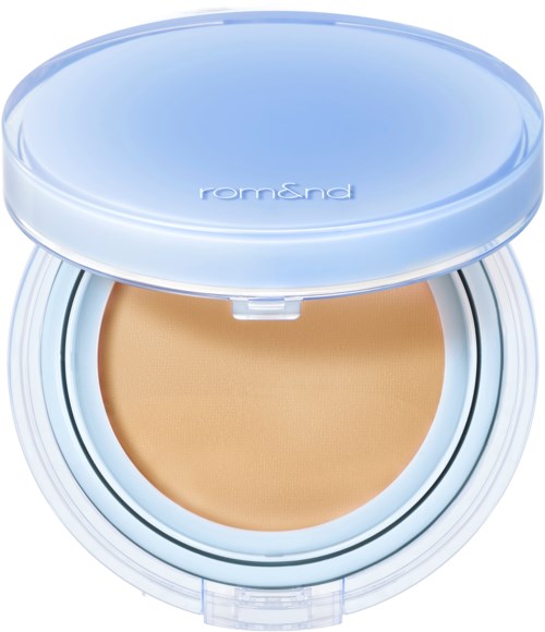 En öppen compact med beige ansiktspuder, blå lock och vit bas. Varumärkesnamnet 'rom&nd' är synligt.