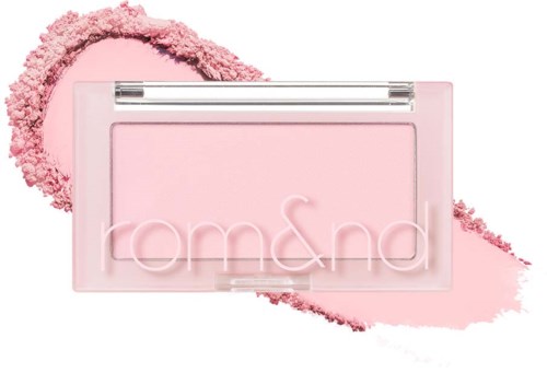 Tom & Sand-logotyp på rosa bakgrund med rosa pulver och färgstänk.