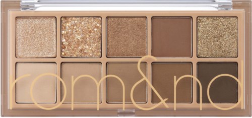 An eyeshadow palette with neutral shades, including glitter and matte finishes, in a clear case with gold lettering.