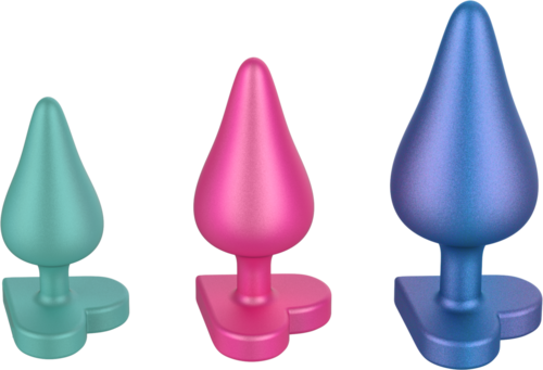 Drei bunte, spitze Gegenstände mit flachen Bases in Grün, Pink und Blau. Sie sehen aus wie Spielzeug oder Dekorationsstücke.