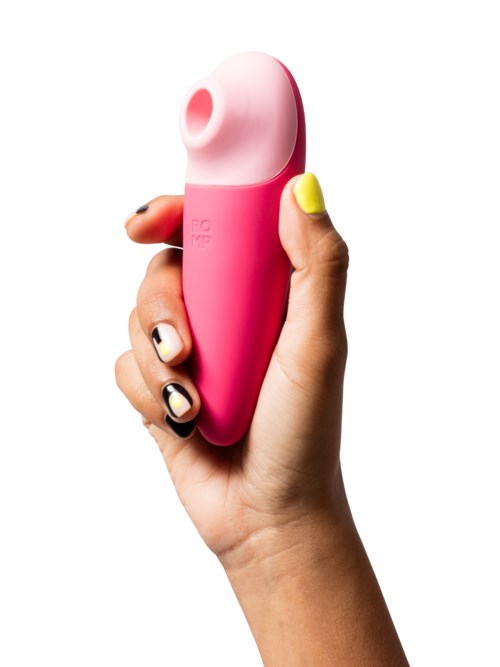 Eine Hand hält ein pinkes und weißes, japanisches Reisbällchen-förmiges Gerät, wahrscheinlich ein Hautpflege- oder Kosmetikprodukt.