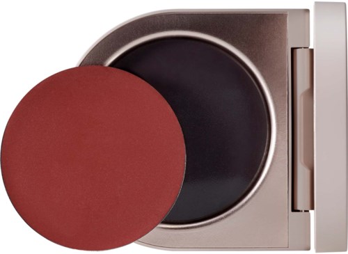 A microwave oven with a red object placed inside. The door is open, showing the dark interior.