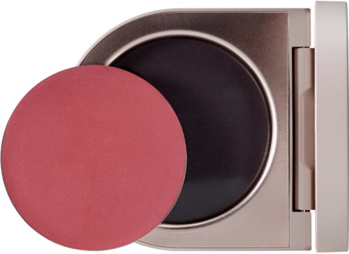 A washing machine with a pink drum cleaner in front of the door.