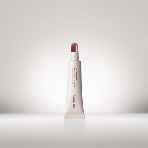 Een lippenbalsemtube staat rechtop met een roze dop, geplaatst op een lichte achtergrond.