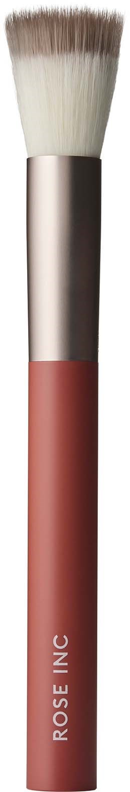 A makeup brush with white bristles, a metallic middle part, and a pink handle with the words "ROSE INC.".