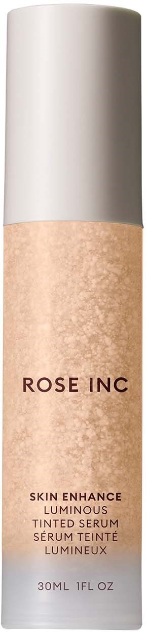 A tube of liquid makeup with a white cap and beige body, labeled 'ROSE INC' and 'Skin Enhance Luminous Tinted Serum'.