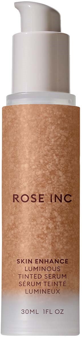 A tall white bottle with pump, label says 'ROSE INC' and 'Skin Enhance Luminous Tinted Serum'.