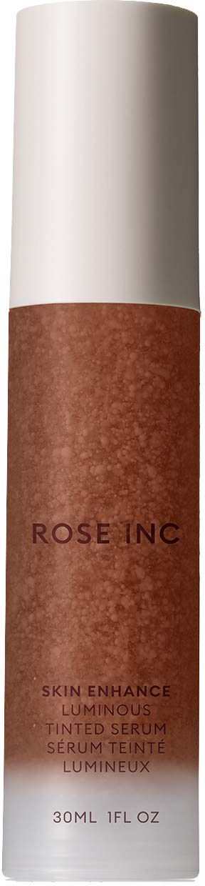 A tall white bottle with a reddish-brown label that says 'ROSE INC' and details about a skin serum.