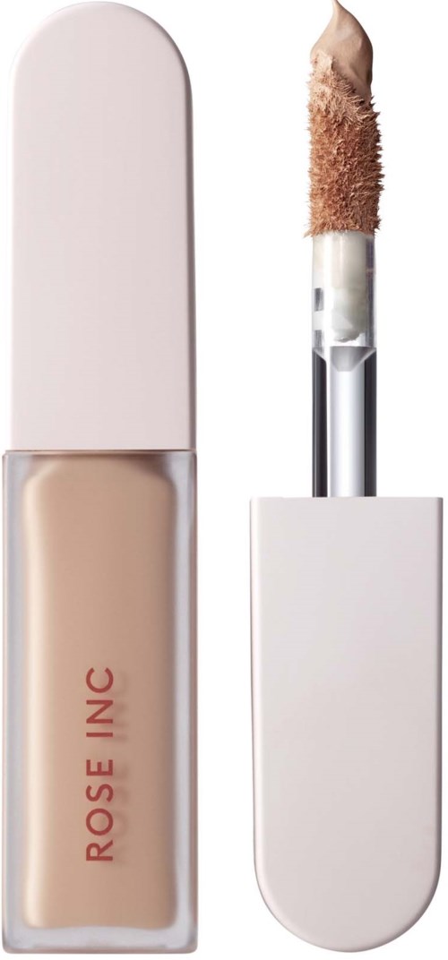 A liquid concealer with a sponge applicator, in a white and beige container, labeled 'Rose Inc.'.