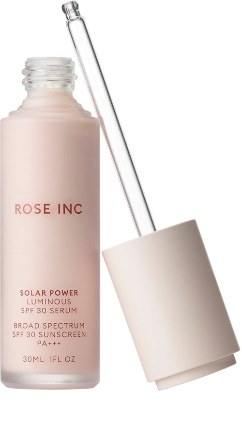 En rosa flaske merket 'ROSE INC' med dråpeteller ved siden av en hvit lokk. Det er solkremserum.