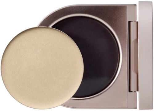 A washing machine opens, with a round, beige detergent dispenser in front of the door.
