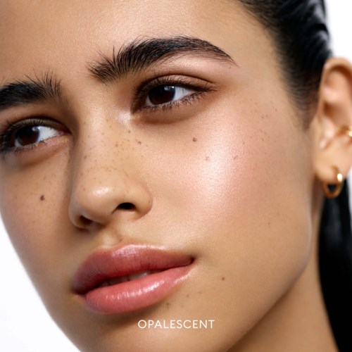 Close-up of a young woman's face with clear skin, dark eyebrows, and slightly parted lips, looking to the side.