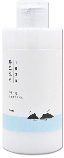 Eine weiße Flasche mit koreanischem Text und einer kleinen Illustration von zwei Steinen im Wasser nahe einem Strand.
