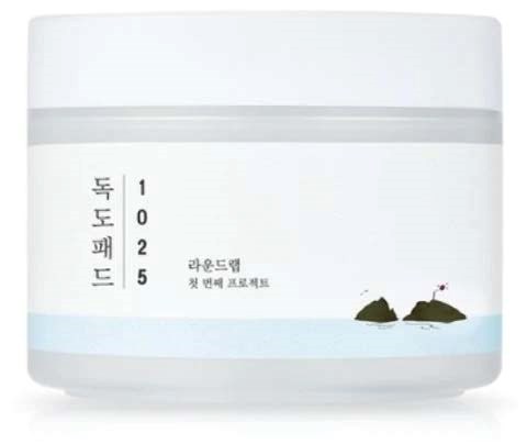 Ein weißer Behälter mit koreanischem Text und kleinen Bildern von zwei Steinen auf Wasser.