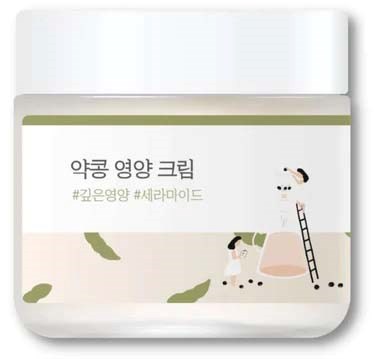 Ein weißer Behälter mit koreanischem Text, kleine Illustration einer Person, Leiter und Steine, möglicherweise ein Hautpflegeprodukt.
