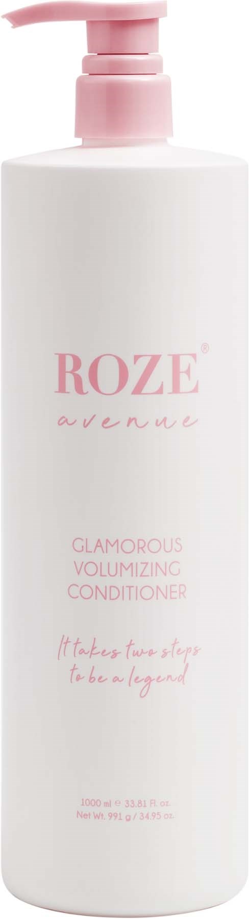 Eine weiße Flasche mit einem pinken Pumpverschluss, beschriftet mit 'ROZE avenue' für volumisierenden Conditioner. Es sagt 'Glamorous' und 'Es braucht zwei, um eine Legende zu sein.'