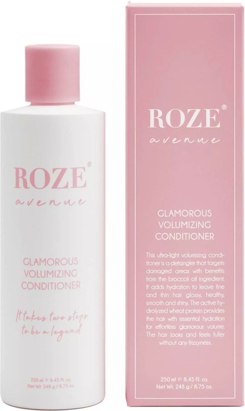 Eine weiße Flasche mit rosa Deckel und ein pinker Karton dahinter, beide beschriftet mit 'Roze avenue' und 'Glamorous Volumizing Conditioner'.