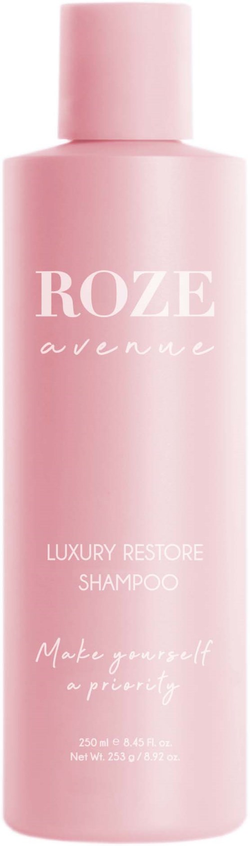 En lång rosa flaska märkt 'ROZE avenue' för lyxig restore-schampo. Den står med texten 'Make yourself a priority.'