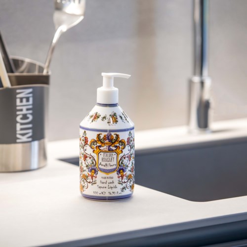 A decorative hand soap bottle with colorful ornate design on a kitchen sink counter.
