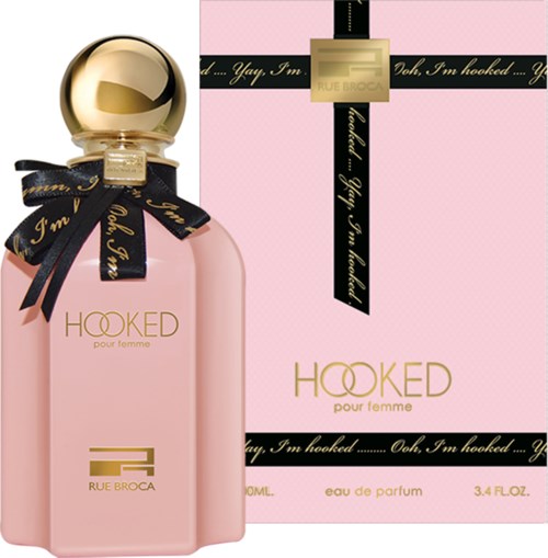 A pink perfume bottle with a gold cap and a black ribbon, next to a pink box with similar design.