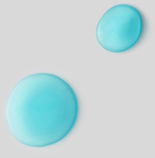 Zwei blaue Tabletten liegen auf hellgrauem Hintergrund, eine größere und eine kleinere.