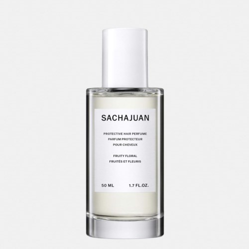 Een doorzichtige fles met witte vloeistof, label 'SACHAJUAN' en 'Protective Hair Perfume', 50 ml, fruitig bloemige geur.