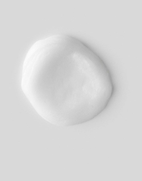 Een wit, glad, rond object op een lichte achtergrond, waarschijnlijk een zacht voedingsmiddel zoals mozzarella of een marshmallow.