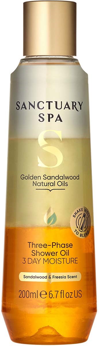 Eine lange Flasche mit goldener Kappe, gekennzeichnet mit Sanctuary Spa, enthält Duschöl mit Sandelbodenduft.