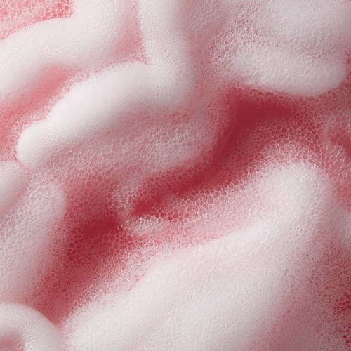 Rosa und weiße Blasen im Schaum, schaffen eine weiche, luftige Textur mit dunkleren Rottönen.