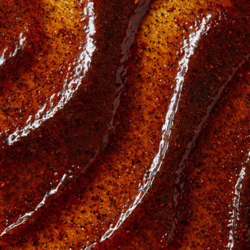 Nahaufnahme von Speckscheiben mit knuspriger, gewürzter und öliger Textur mit Fettstreifen.