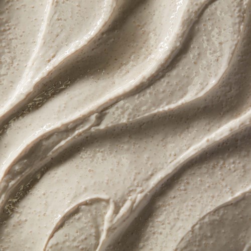 Gewirbelte, cremige, beige Glasur mit kleinen Flecken, glatte Textur und weiche Falten.