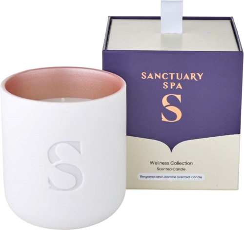Ein weißer Kerzenhalter mit einem großen 'S' und eine lila und weiße Schachtel mit Sanctuary Spa S duftender Kerze.