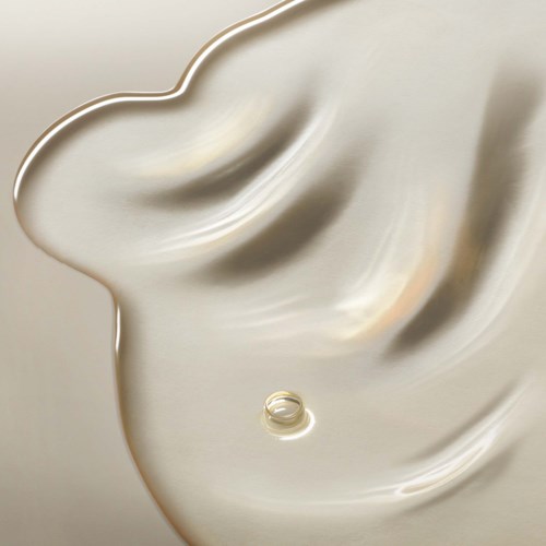 Nahaufnahme einer glatten, glänzenden Silberfläche mit weichen Kurven und einer kleinen ringförmigen Detail.