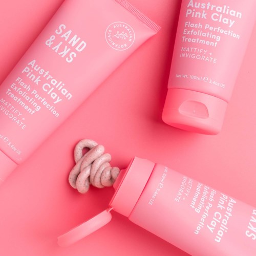 Rosa Hautpflegeprodukte, Tube und Flasche, mit cremiger oder schäumender Substanz, auf rosa Hintergrund.