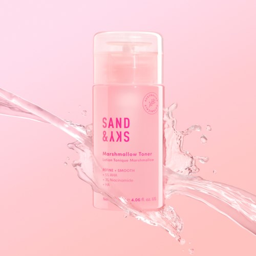 Pinke Flasche mit Marshmallow-Toner und Wasser, gekennzeichnet 'SAND & SKS', vor pinkem Hintergrund.