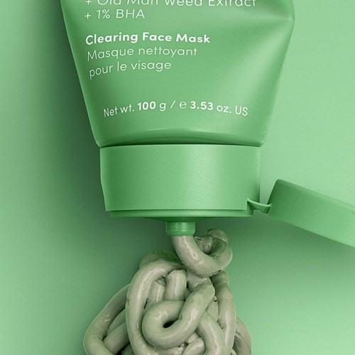 Eine grüne Gesichtsmaske-Tube mit etwas Maske, die herausquillt, und einem passenden grünen Verschluss. Einfaches, sauberes Design.
