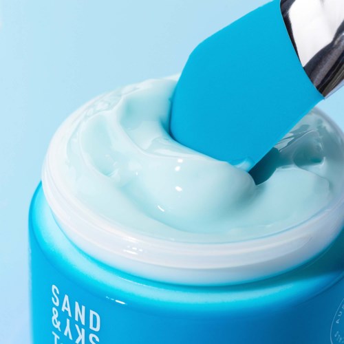 Ein blauer Behälter mit Zahnpasta, darauf eine blaue Zahnbürste und weiße Paste.