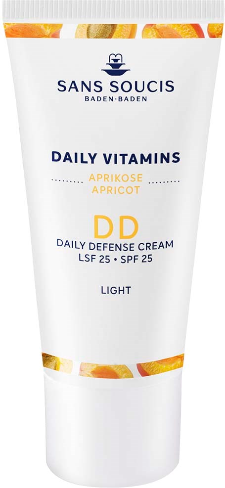Eine weiße Tube Gesichtscreme mit orangefarbenen und gelben Reflexionen, beschriftet 'Sans Soucis' und 'Daily Vitamins' für das Gesicht.