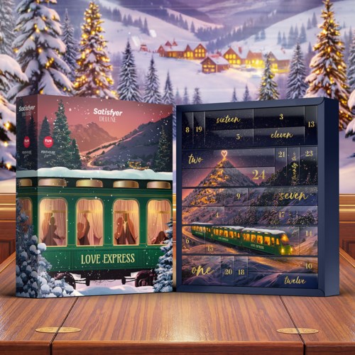 En juldekorerad adventskalender med tåg och snölandskap, på ett träbord med snötäckta träd i bakgrunden.