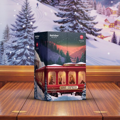 En festlig låda med ett rött tåg märkt Love Express, placerad framför en vintrig snölandskap med granar och berg.