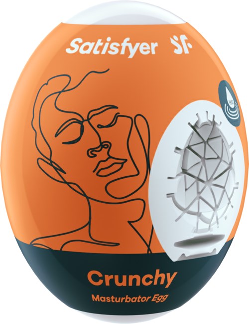 An orange and black egg-shaped package with a line drawing of a face, the words "Satisfyer" and "Crunchy," and a small white device.