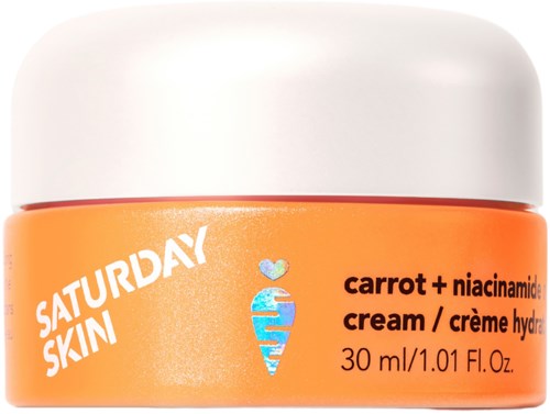 Een kleine oranje pot met witte deksel, gelabeld 'Saturday Skin' en bevat wortel en niacinamide.