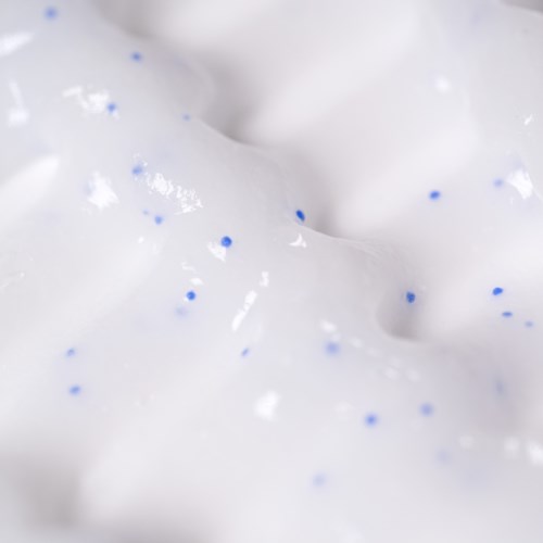 Close-up van witte stof met kleine blauwe stippen, ziet er zacht en textuurvol uit.